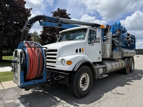 Front driver-side angle of a 2006 Vactor 2100 combination sewer cleaner with front-mounted hose reel.